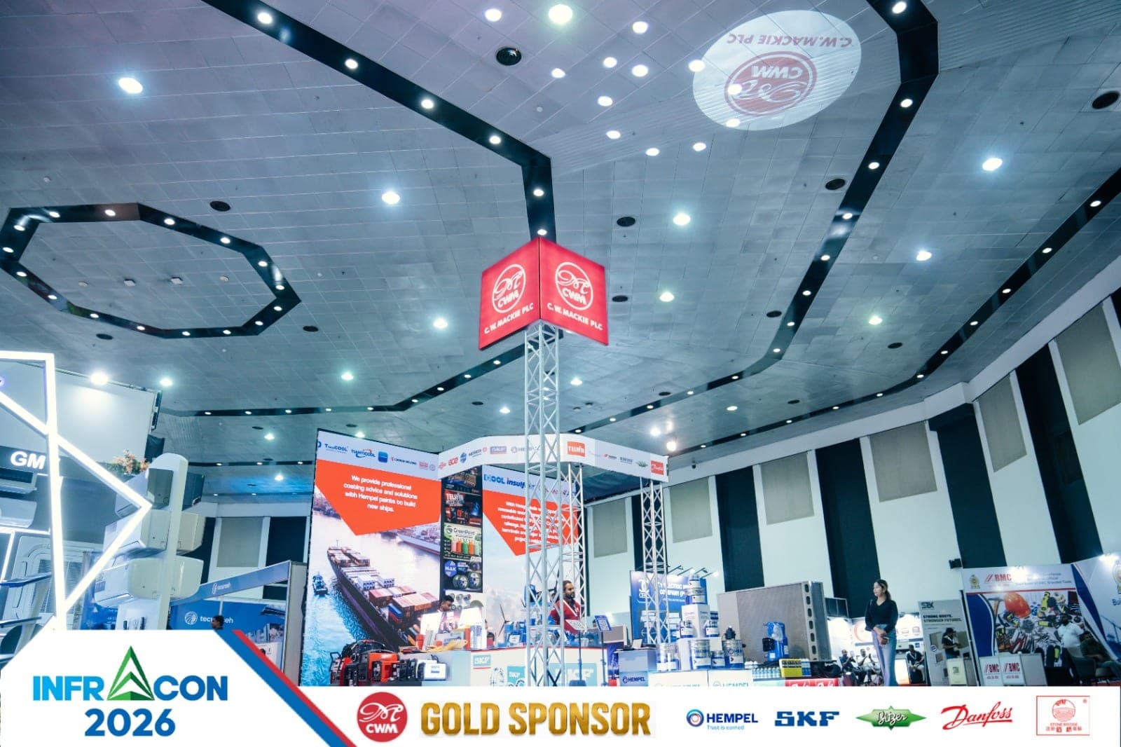 Illuminated overhead sponsor sign at an exhibition hall