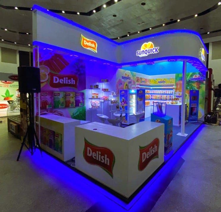 Delish corner stall with blue LED cove lighting and a white service counter