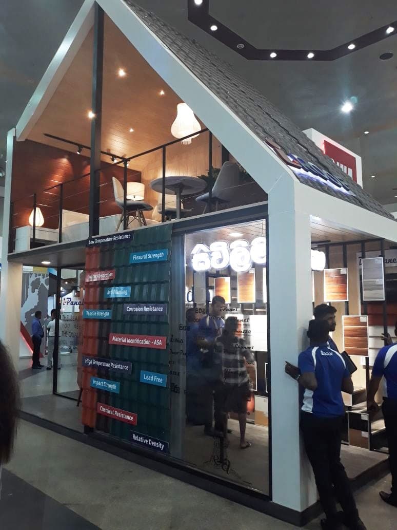 Two-storey glass-fronted showroom stand with visitors at the entrance