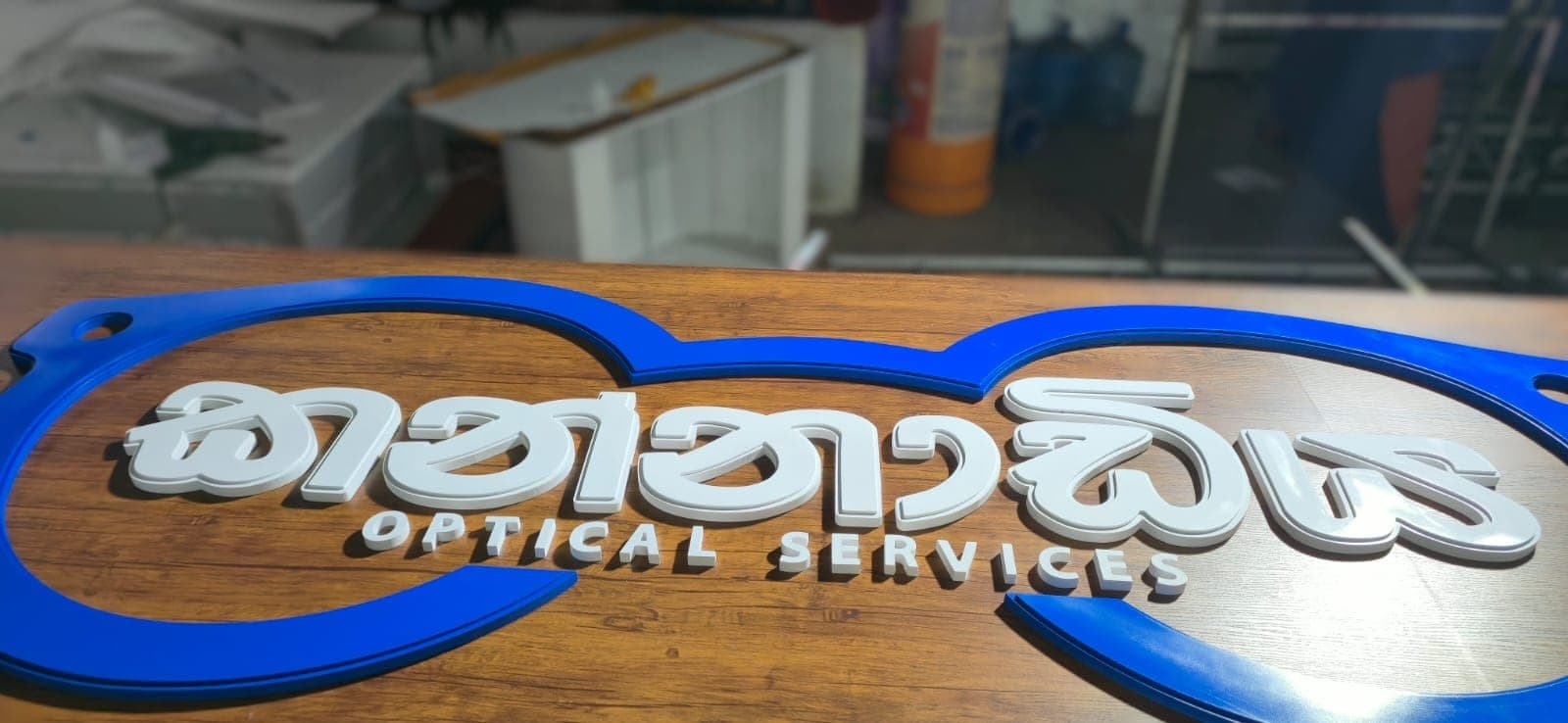 Kannadiya Optical Services 3D-letter dealer board on a timber panel